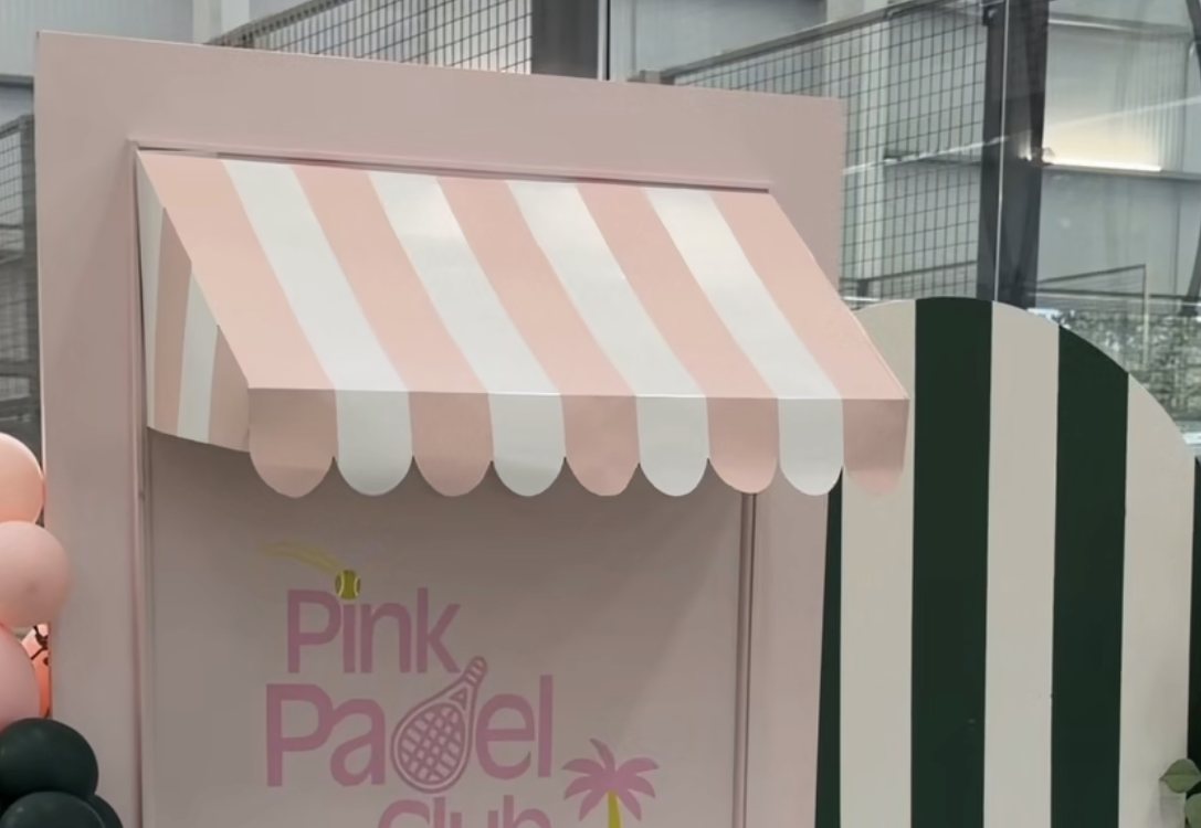 Pink Padel Club photo wall with pink striped awning