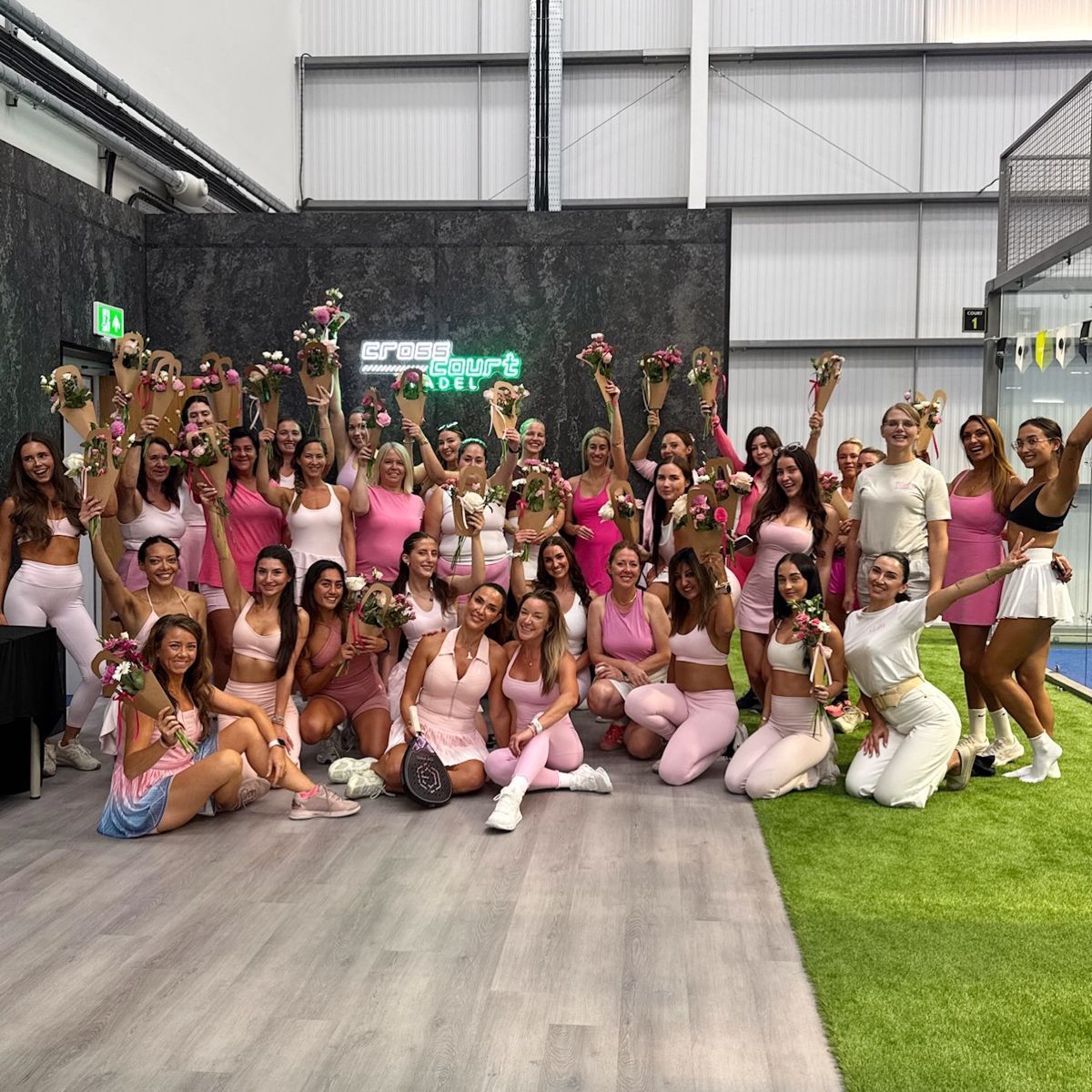 Pink Padel Club players celebrating with flowers at Cross Court Padel